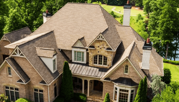 Aerial view of a large brick house with multiple gabled roofs and chimneys