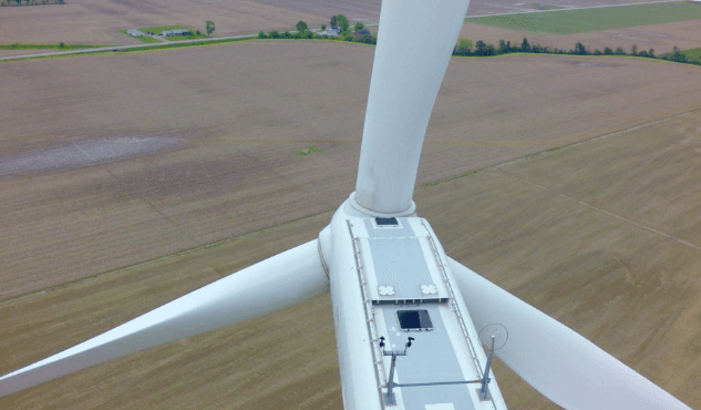 A wind turbine seen from above with three blades attached to the nacelle