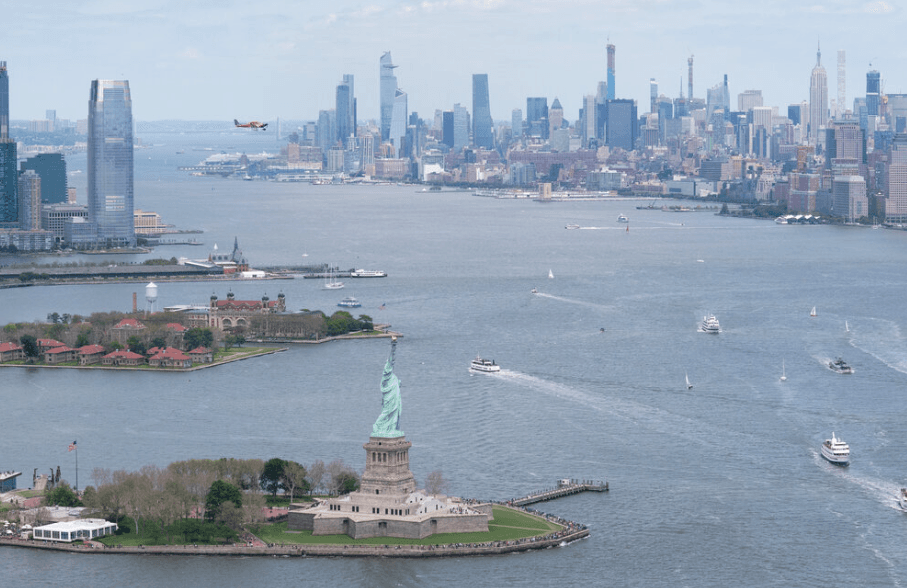 Statue of Liberty on Liberty Island with the Manhattan skyline and harbor boats in view