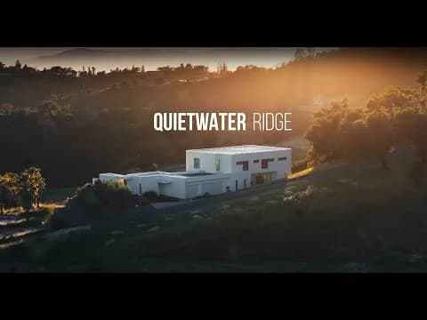 Aerial view of white modern buildings on a hillside at sunset with trees, Quietwater Ridge text overlay