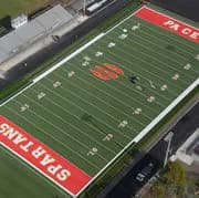 Aerial view of a football field with red end zones; Spartans lettering visible in the left end zone
