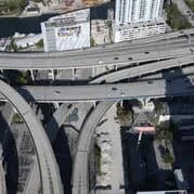 Aerial view of a multi-level highway interchange with overpasses and surrounding buildings