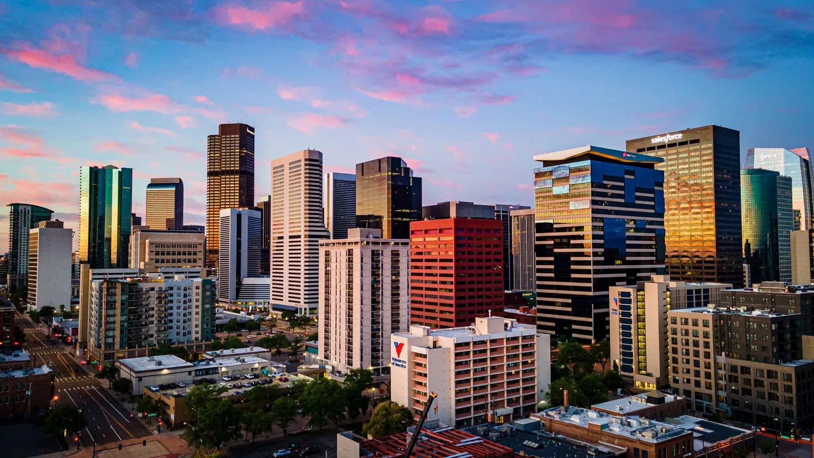 City skyline with modern high-rise buildings at sunset, pink clouds in the sky