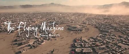 Aerial view of a desert town with grid-like buildings and distant hills; cursive The Flying Machine overlay