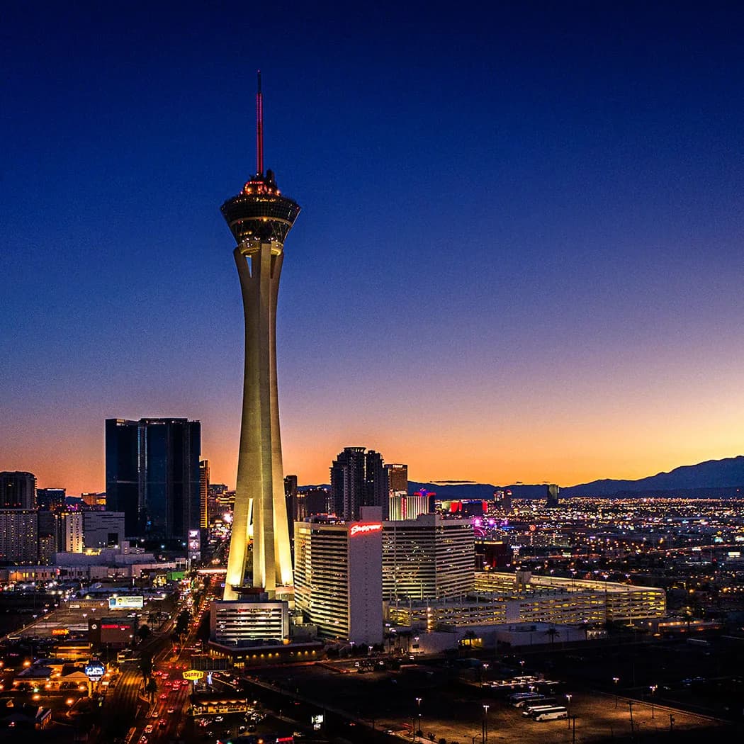 Las Vegas skyline at dusk featuring the Stratosphere Tower and illuminated hotels and streets
