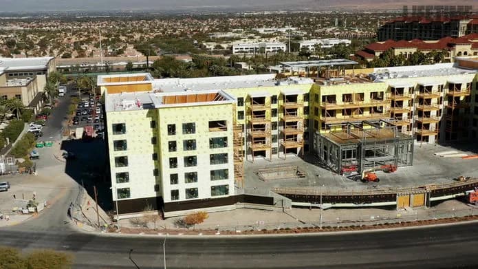 Aerial view of a construction site with several partially completed buildings and scaffolding
