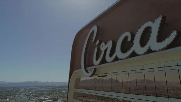 Circa logo on a curved building facade, with city and mountains in the distance