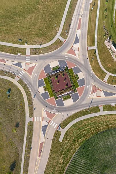 Aerial view of a roundabout with a central garden and decorative paving around it