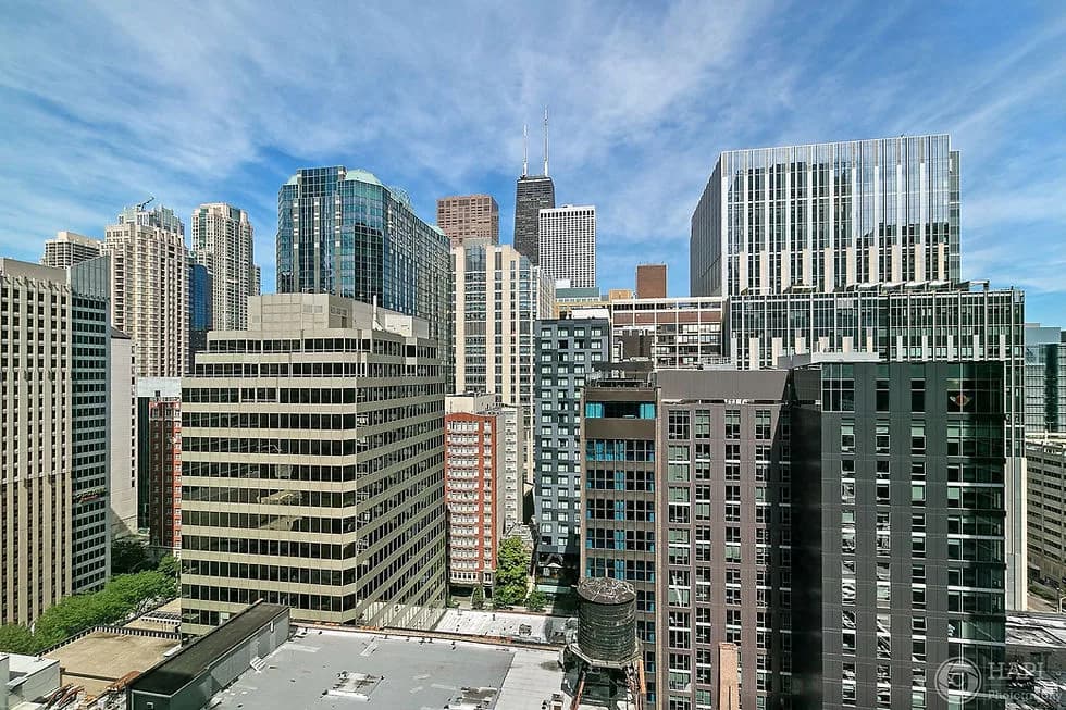 Aerial view of a downtown city skyline with many high-rise buildings under a clear blue sky