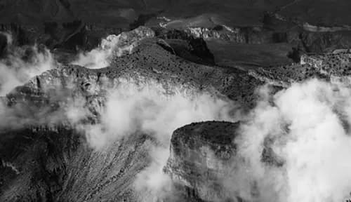 Black and white rugged mountain landscape with rocky cliffs and clouds