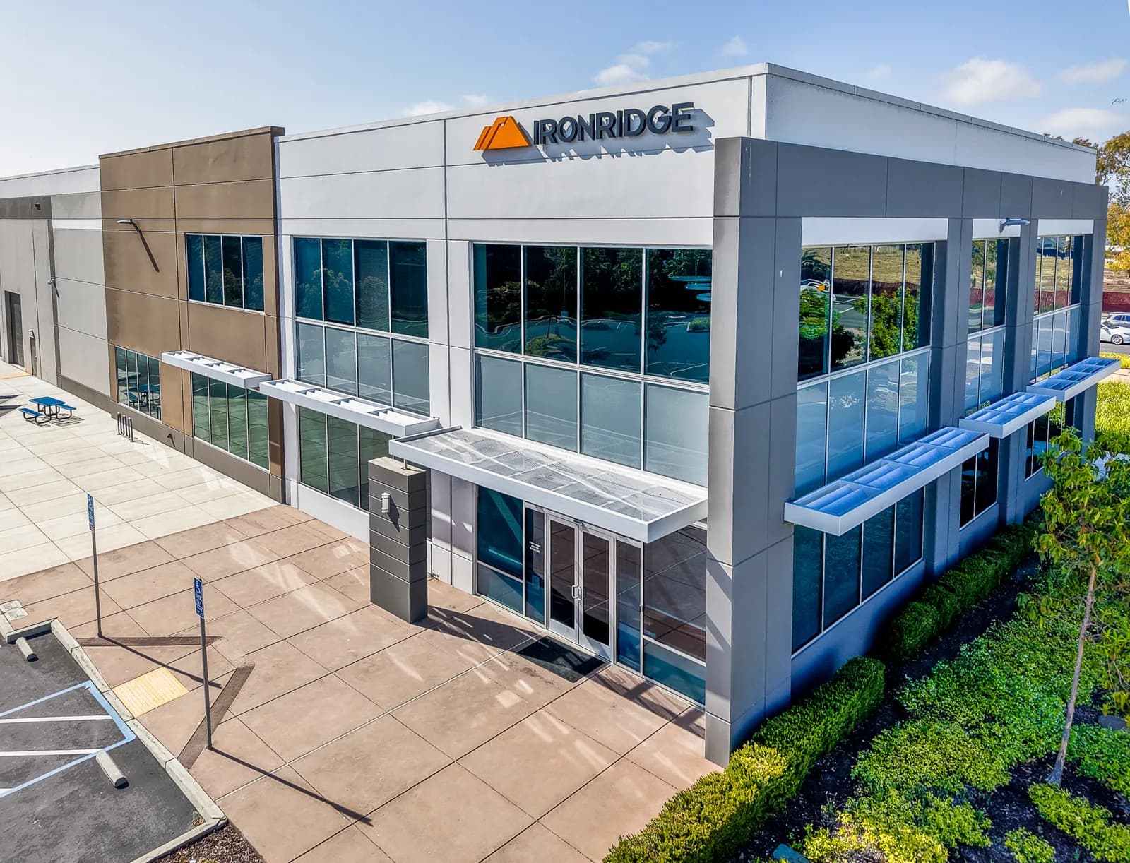 A modern two-story office building with large glass windows and the IronRidge logo on the facade