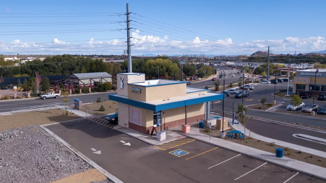 Drive-through coffee shop with parking lot and surrounding roads seen from above
