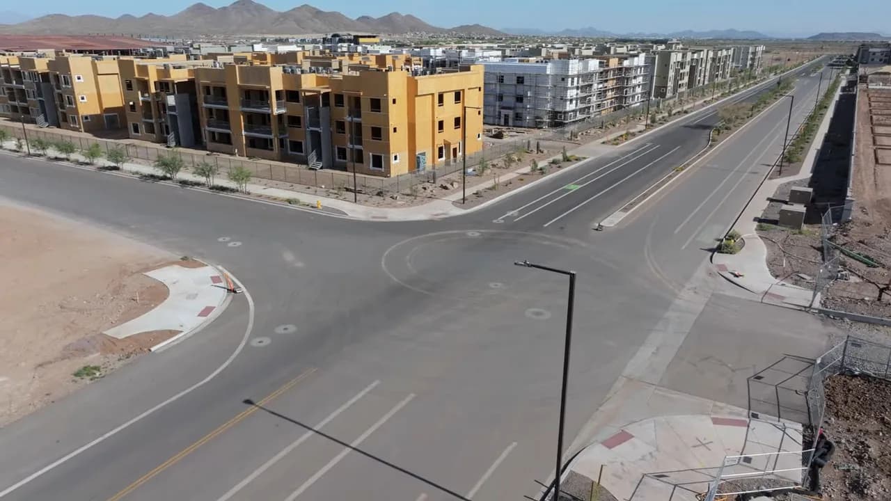 Aerial view of a wide intersection with new apartment buildings and empty streets
