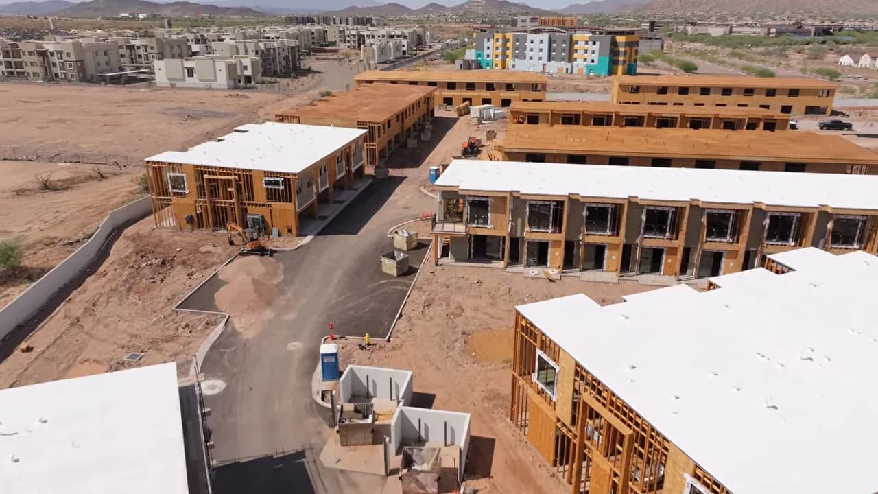 Aerial view of multiunit residential buildings under construction in a desert landscape