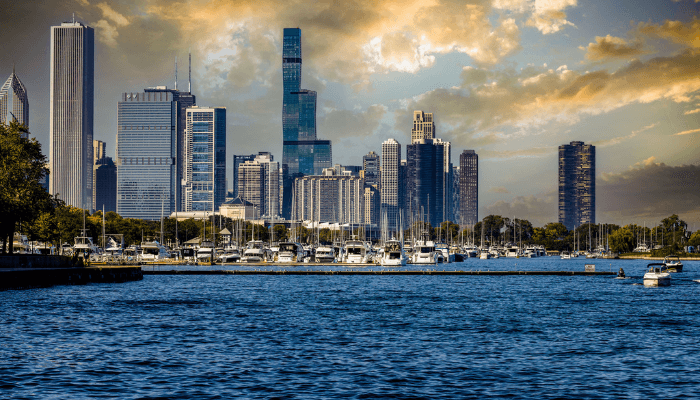 City skyline with tall skyscrapers beside a marina and boats on blue water