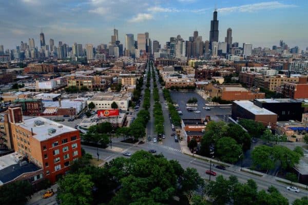Drone view of a city skyline with a long tree-lined avenue converging toward downtown