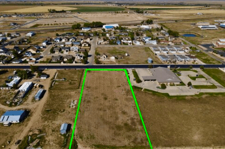 Aerial view of a residential area with a large rectangular plot outlined in bright green