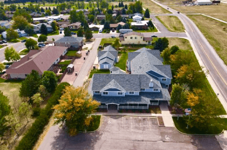 Aerial view of a suburban neighborhood with houses, driveways and trees