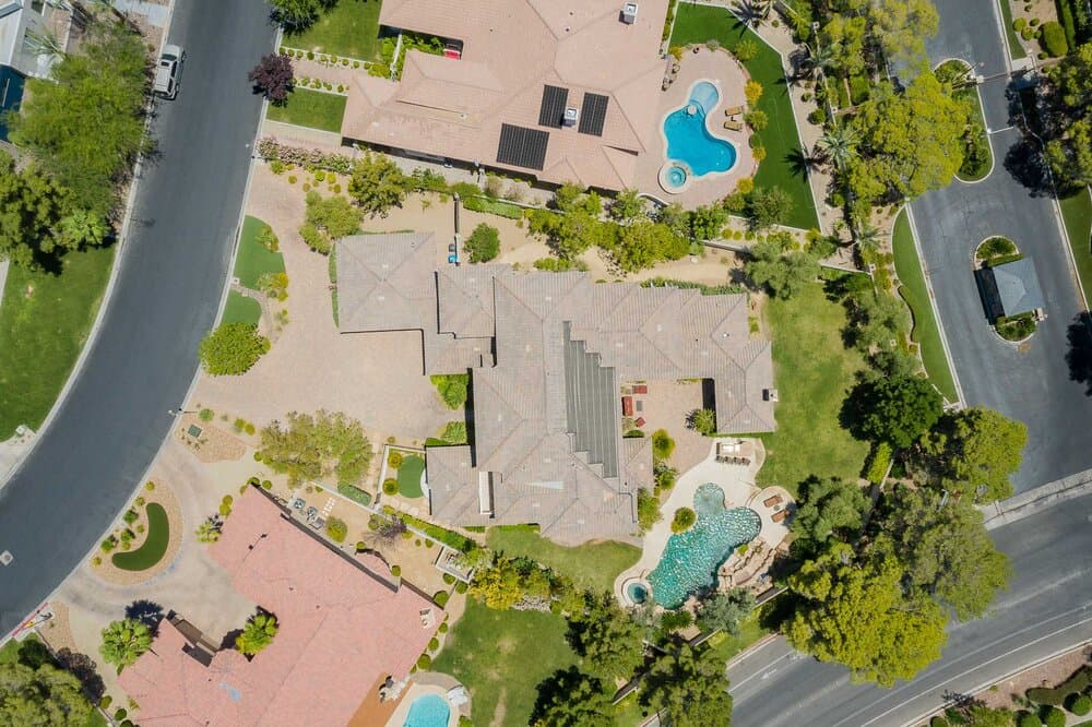 Aerial view of a residential neighborhood with large houses and several pools