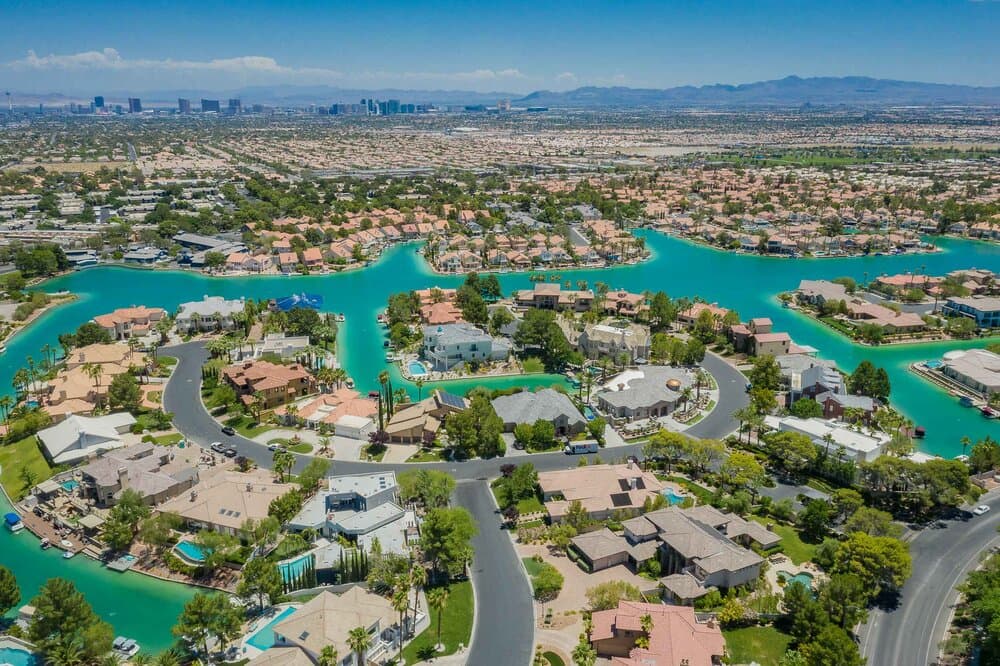 Aerial view of a residential community with turquoise canals winding through houses