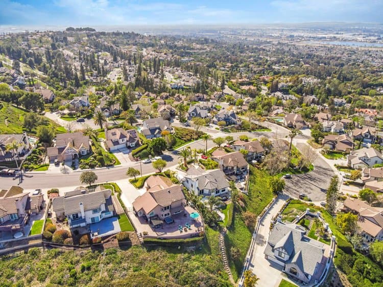 Aerial view of a suburban neighborhood with streets, houses, and greenery