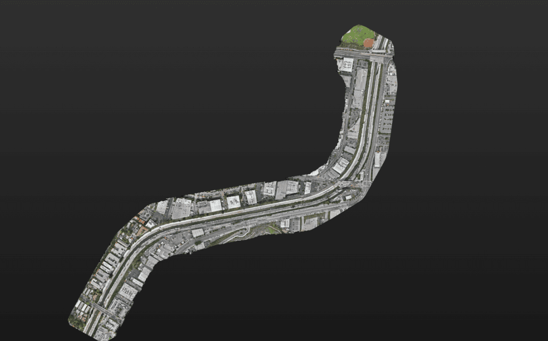 Aerial view of a winding urban street network with buildings, set against a dark background