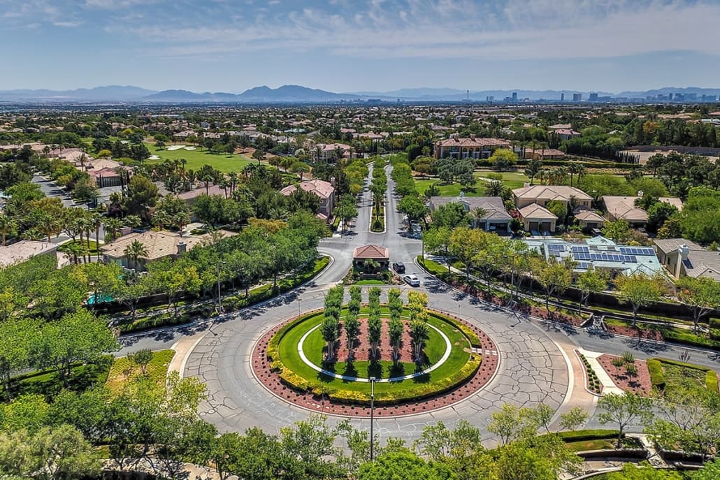 Aerial view of a circular roundabout with a landscaped center, tree-lined streets, and suburban homes