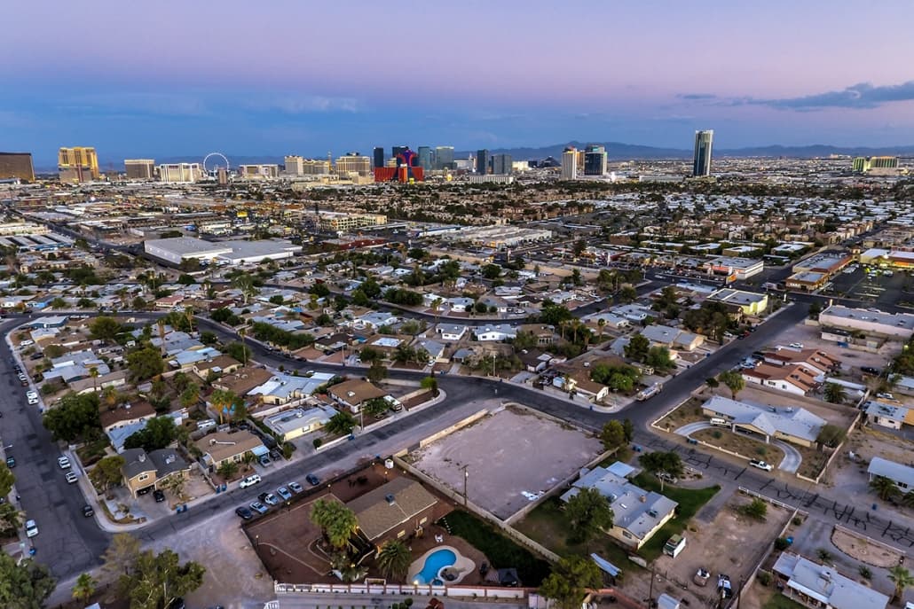 Aerial view of a residential neighborhood with a distant city skyline and a ferris wheel
