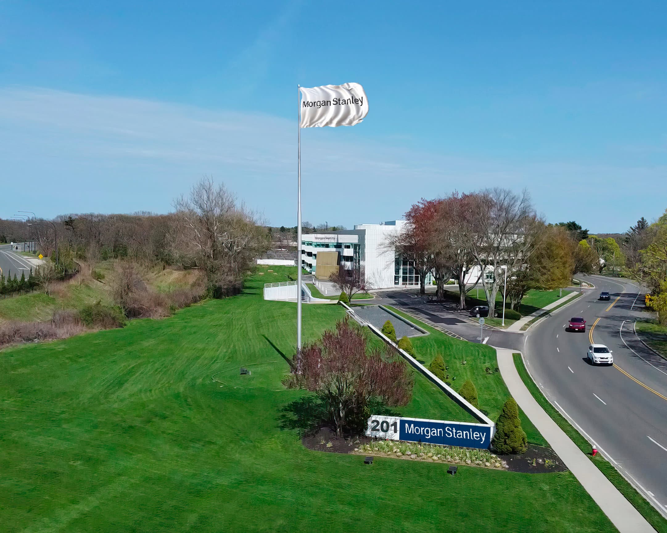 White flag bearing Morgan Stanley logo on a tall pole in front of a modern building and curved road